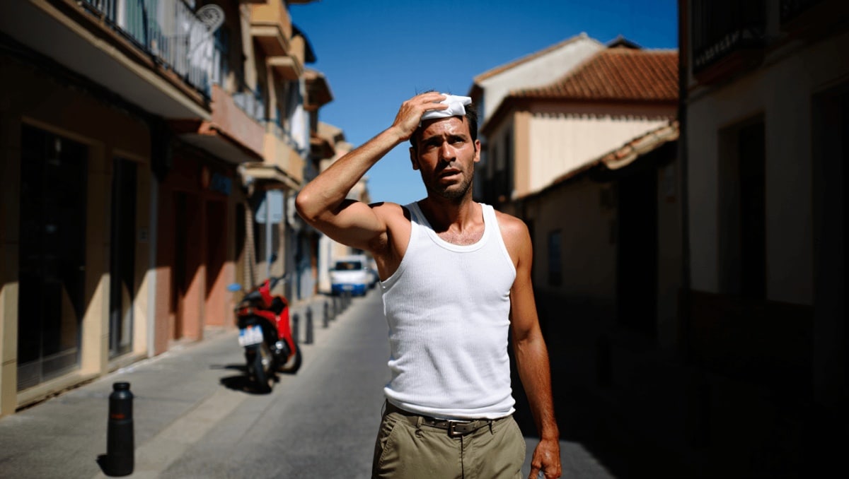 Un hombre se resguarda del sol de Córdoba con un paraguas. (Foto: Guillermo Morales)