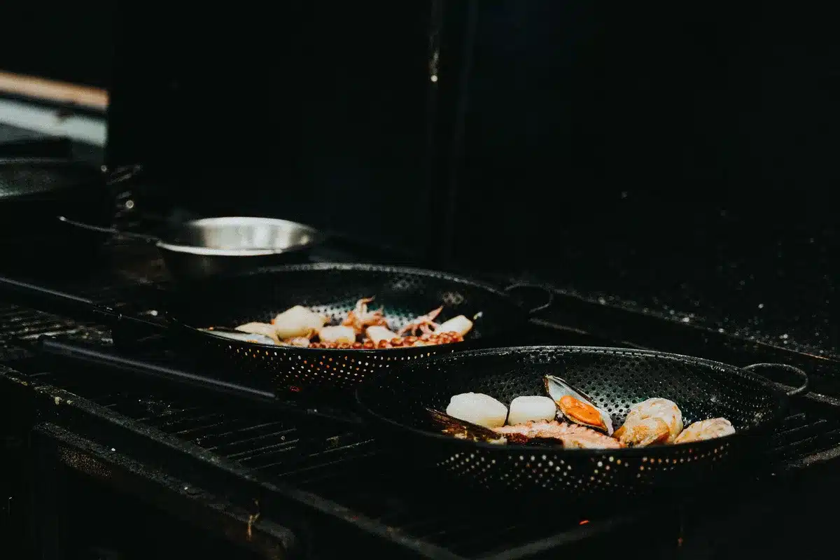 Pequeños cefalópodos recién cocinados a la plancha en una barra costera, dorados y brillantes.