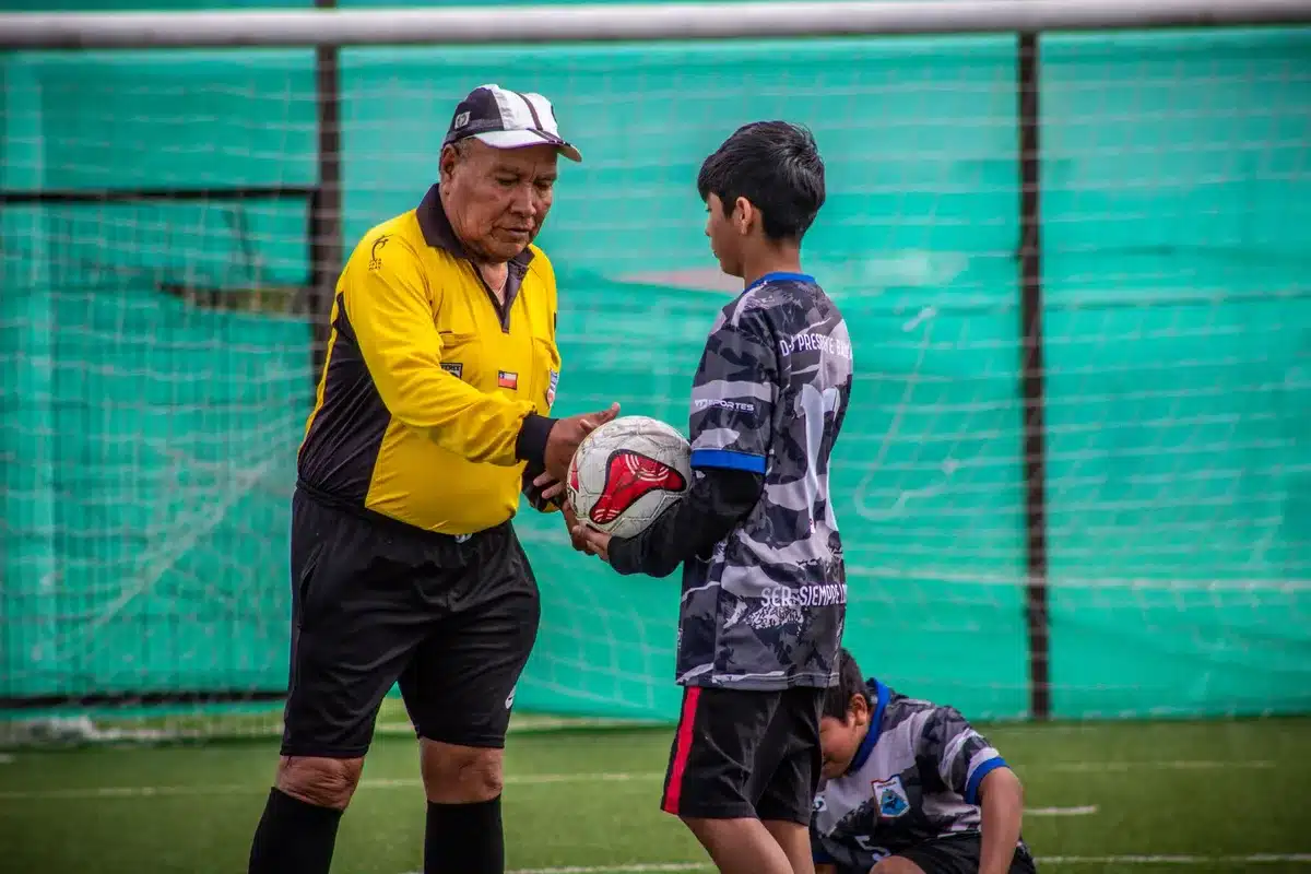 Futbolista experimentado enseñando a un jugador más joven en el vestuario