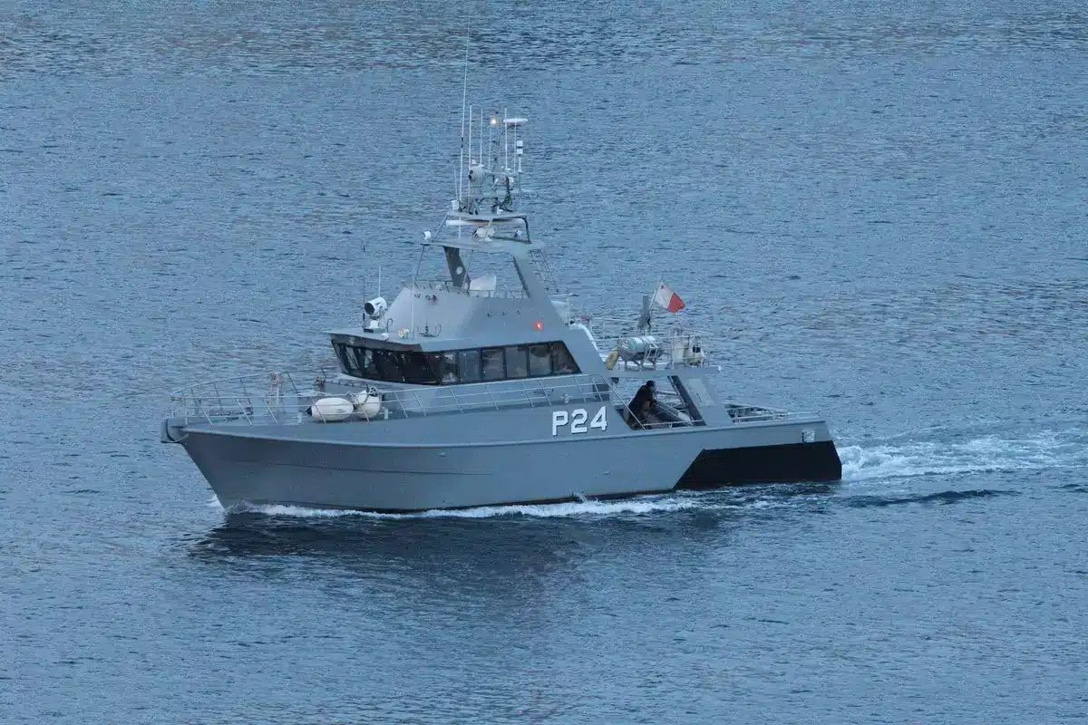 Patrulla militar en puesto fronterizo costero con barcos de vigilancia y personal de seguridad en aguas territoriales
