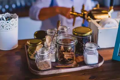 Recipientes uniformes para especias organizados en la encimera de una cocina limpia y ordenada.
