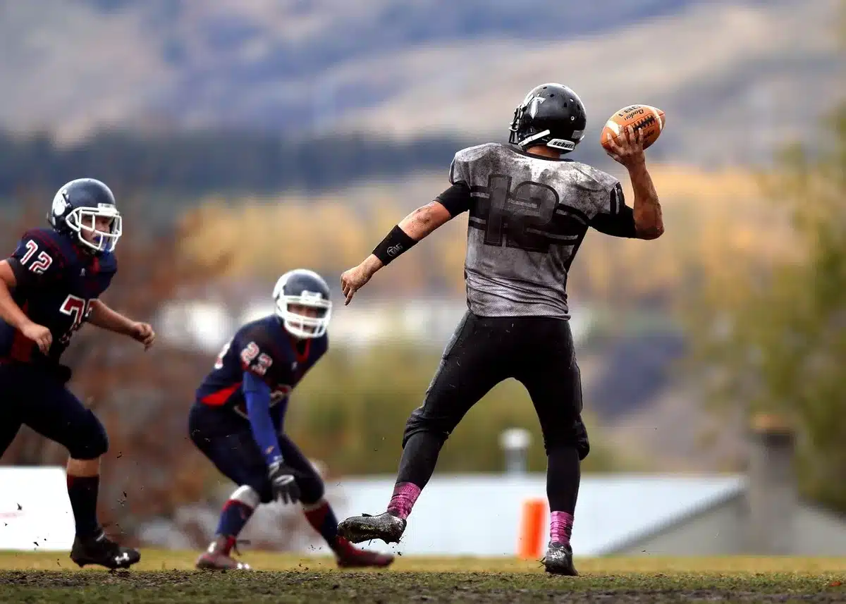 Quarterback lanzando un pase con receptores en acción