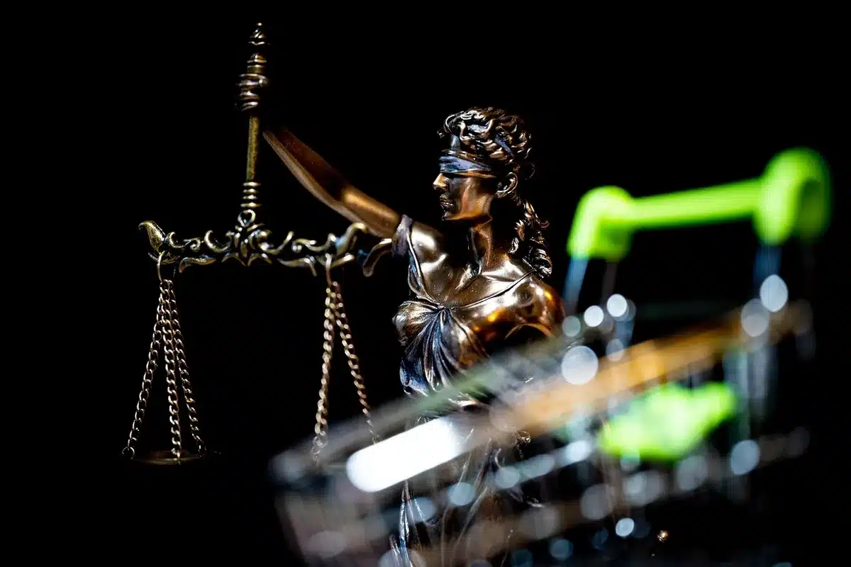 Balanza de la justicia junto a documentos en una mesa de juzgado