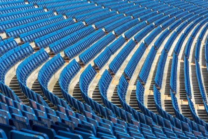 Tenista ejecutando un saque potente en la noche bajo iluminación de estadio