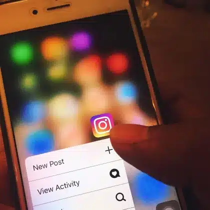 Persona mirando un feed de noticias en móvil con contenido editorial y patrocinado mezclado