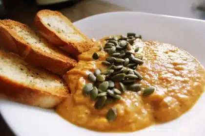 Cuenco de sopa de tomate tradicional con pan rústico y albahaca fresca