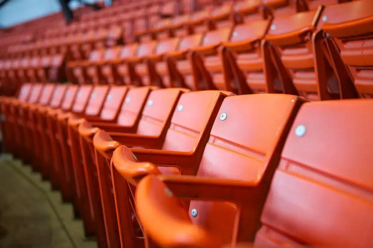 Grada vacía con balón y bufanda en un estadio al atardecer