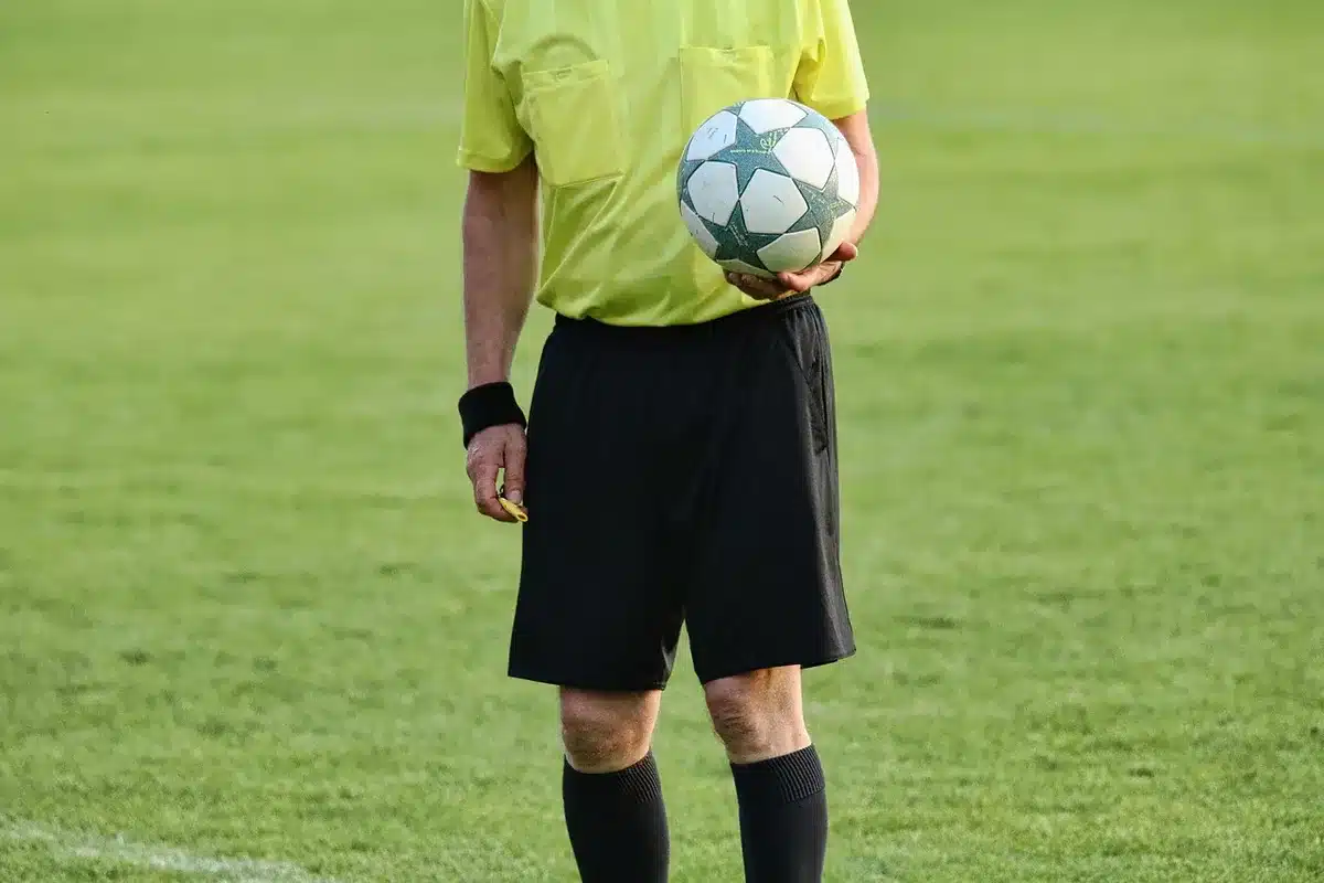 Árbitro revisando el monitor del VAR durante un partido