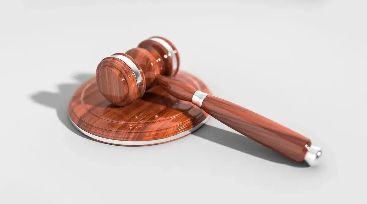 Entrada de un tribunal y expedientes judiciales sobre una mesa
