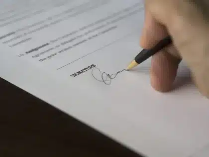 Manos anónimas ordenando documentos y carpetas en una mesa de sala de vistas