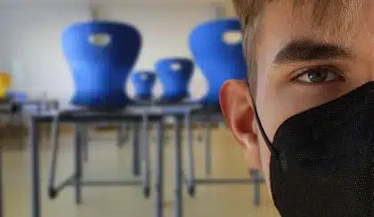 Aula vacía con sillas, libros y pizarra que evoca debate sobre resultados educativos