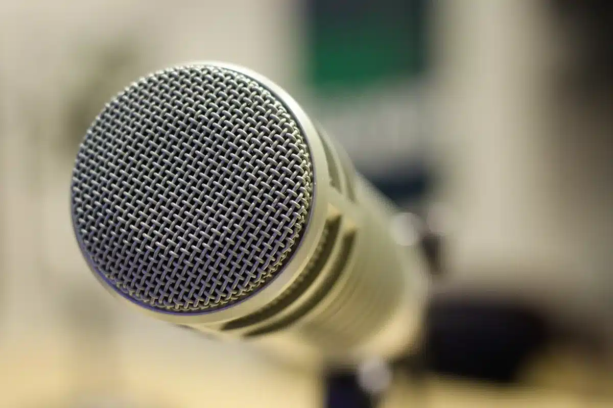 Micrófono en estudio junto a una pantalla con gráficos digitales