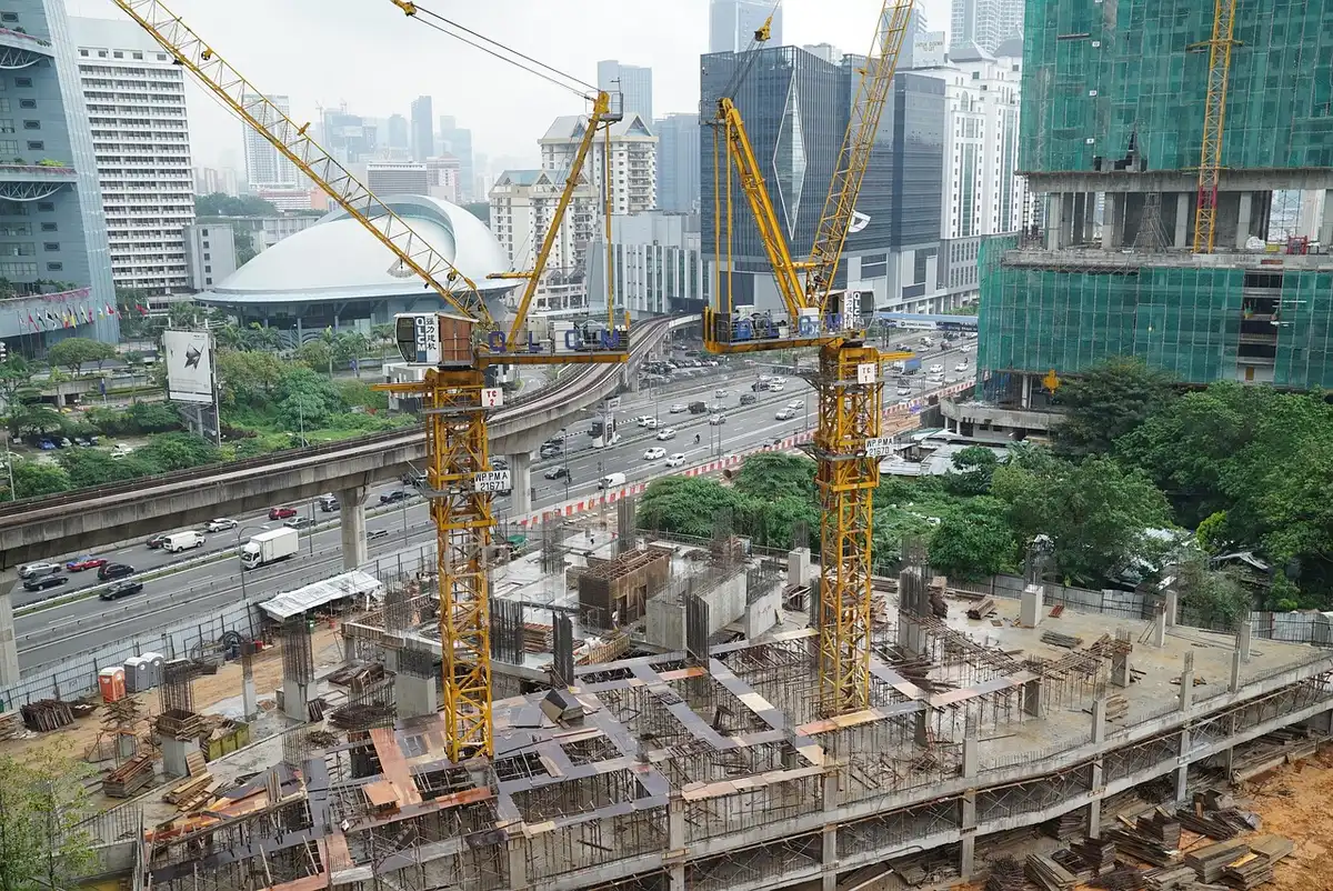 Obreros y grúa en una obra de vivienda pública en construcción