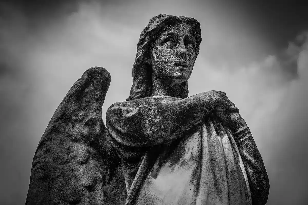 Estatua en el Retiro con ofrenda floral y personas alrededor